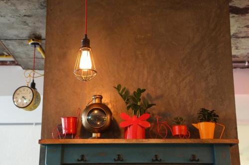a light hanging over a shelf with plants and a clock at Hotel Deccan Serai, HITEC CITY, HYDERABAD in Hyderabad