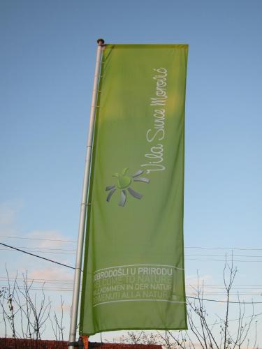 a green flag with a flower on it at Vila Sunce Morovic in Morović