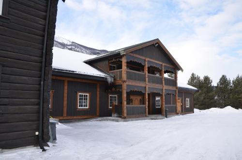 a large wooden building with snow on the ground at Toftemo Turiststasjon in Dovre