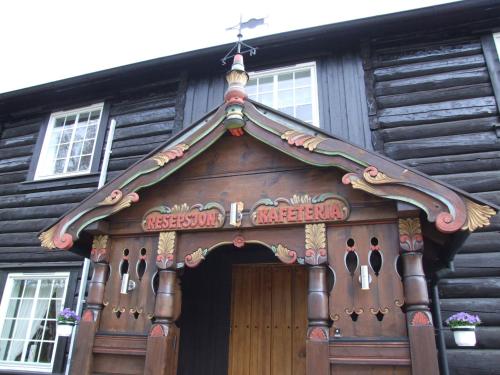 a wooden house with a sign above the door at Toftemo Turiststasjon in Dovre