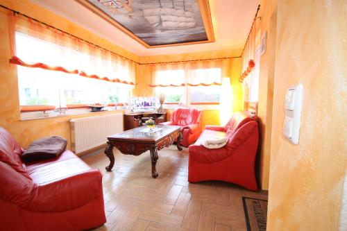 a living room with two red chairs and a table at Feriendomizil am Hafen in Zingst