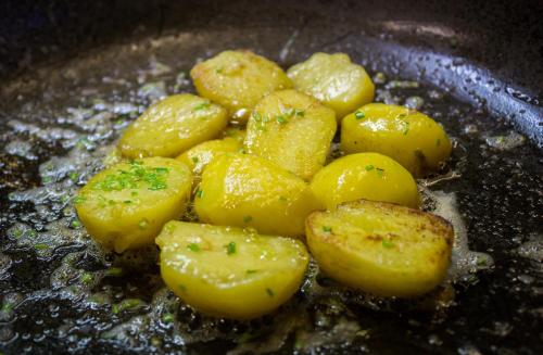 a bunch of potatoes cooking in a wok at Hotel Krona Domžale in Domžale