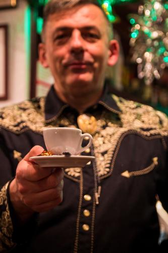 a man holding a cup and a plate of food at Hotel Krona Domžale in Domžale