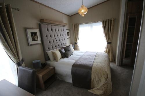 um quarto com uma cama grande e uma janela em Tweed Lodge em Perth