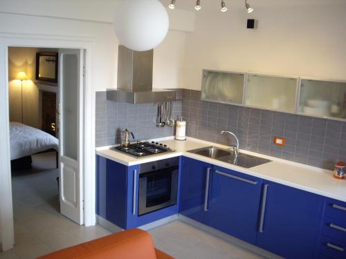 cocina azul con fregadero y fogones en Sea view apartment 10 minute walk to the sea, en San Vito Chietino