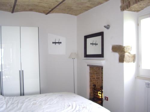 Dormitorio blanco con cama y chimenea en Sea view apartment 10 minute walk to the sea, en San Vito Chietino