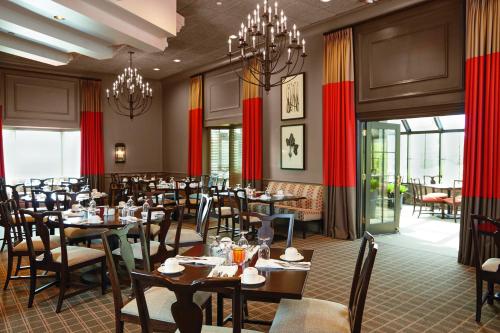 Ethan Allen Hotel في دانبري: غرفة طعام بها طاولات وكراسي وثريات