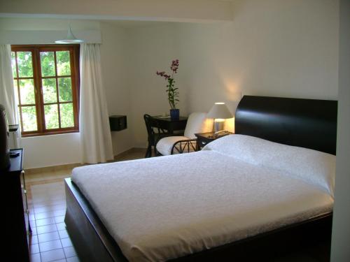ein Schlafzimmer mit einem Bett und einem Stuhl und einem Fenster in der Unterkunft Sosua by the Sea in Sosúa