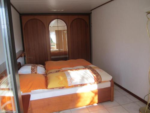 a small bedroom with a bed with a mirror at Haus Alexander in Mechernich