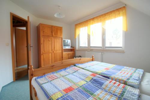 a bedroom with a bed with a quilt on it at Feriendomizil am Hafen in Zingst
