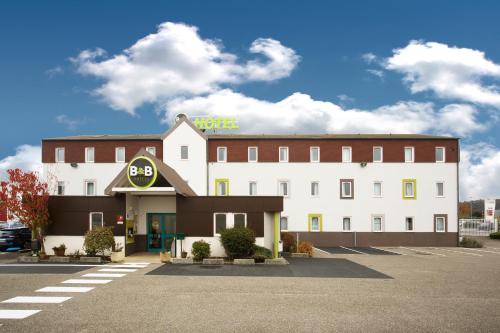 a hotel building with a hotel sign on top of it at B&B HOTEL Lyon Saint-Bonnet Mi-Plaine in Saint-Bonnet-de-Mure