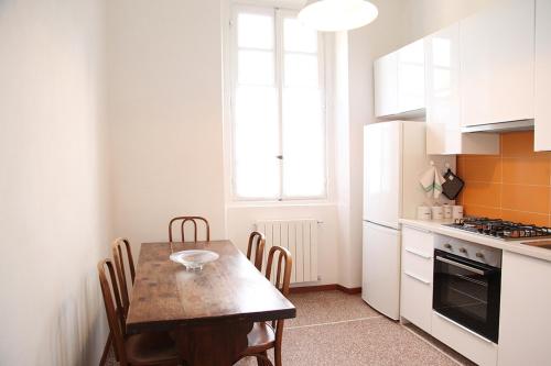 kuchnia z drewnianym stołem, stołem i krzesłami w obiekcie Casa Berra w Mediolanie
