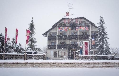 a large building in the snow with flags at Hotel Krona Domžale in Domžale