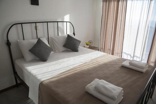 a bedroom with a large bed with two towels on it at GONIO Mgzavrebi III Apartment 403 in Gonio