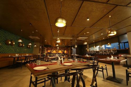 a restaurant with a large wooden table and chairs at Hotel Deccan Serai, HITEC CITY, HYDERABAD in Hyderabad