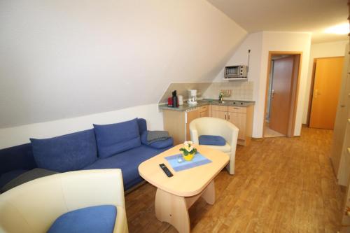 a living room with a blue couch and a table at Feriendomizil am Hafen in Zingst