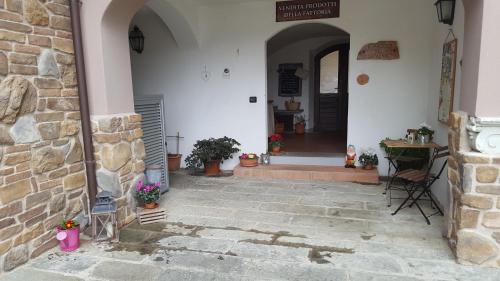 an entrance to a white building with a stone wall at B&B Podere Montese in Villafranca in Lunigiana