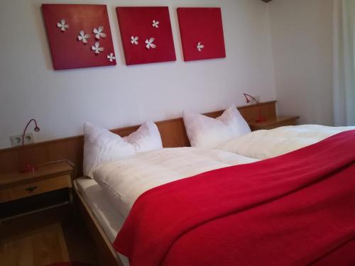 a bedroom with a bed with a red blanket on it at Gästehaus Anna in Grossarl