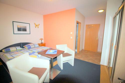 a bedroom with a bed and a table and a chair at Feriendomizil am Hafen in Zingst