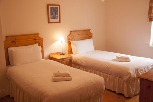 Habitación de hotel con 2 camas y toallas. en Courtyard Holiday Cottages No 9 en Bettystown