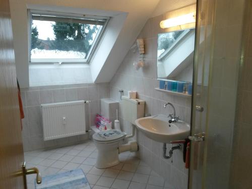ein Bad mit einem WC, einem Waschbecken und einem Fenster in der Unterkunft Schapers Ferienwohnungen in Emmerthal