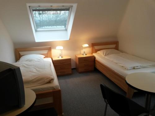 Emmerthalにあるシャッパース フェーリエンボーヌンゲンのベッドルーム1室(ベッド2台、テレビ、窓付)