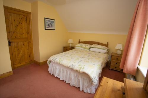 a bedroom with a bed and a wooden door at Willow Grove Holiday Homes No 3 by Trident Holiday Homes in Rosslare