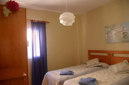 sypialnia z 2 łóżkami i lampką w obiekcie Apartamentos Gran Rey w mieście Valle Gran Rey