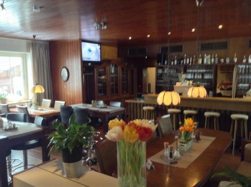 a restaurant with tables and chairs with flowers on them at Waldhotel "Peter aufm Berge" in Bielefeld