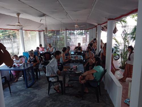 un grupo de personas sentadas en mesas en un restaurante en Hotel Peacock en Kovalam