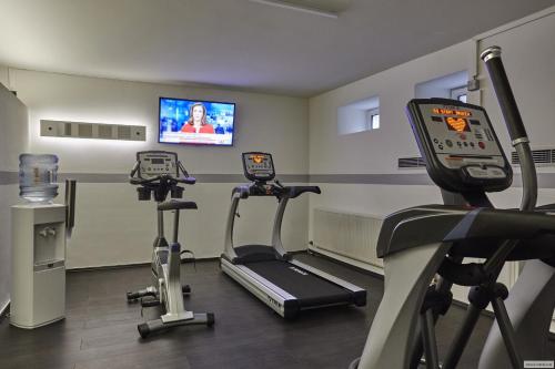 a gym with two exercise bikes and a tv at H+ Hotel Köln Hürth in Hürth