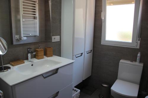 アルムニェーカルにあるBella vida en Almunecarのバスルーム(洗面台、トイレ付)、窓が備わります。