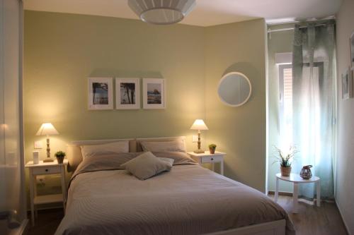 アルムニェーカルにあるBella vida en Almunecarのベッドルーム1室(大型ベッド1台、テーブル2台、ランプ2つ付)