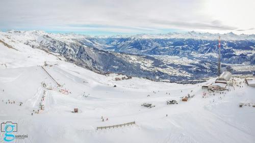 a group of people skiing down a snow covered mountain at Le Manoir de Champlan in Grimisuat
