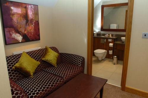 ein Wohnzimmer mit einem Sofa und einem Badezimmer in der Unterkunft The Bear's Paw in Warmingham