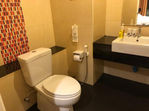 een badkamer met een wit toilet en een wastafel bij Naithon Beach Residence in Nai Thon Beach