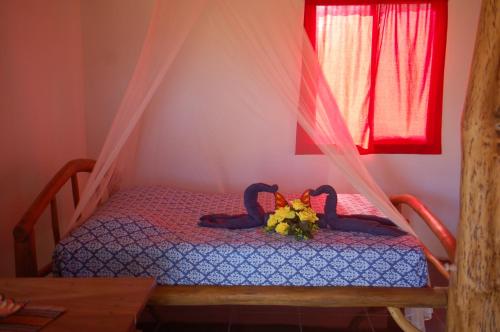 a bedroom with a bed with two swans on it at Casa bungalow Ital-Tico in Paraíso