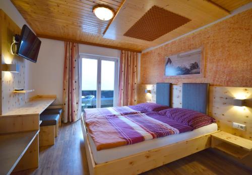 a bedroom with a bed and a desk in it at Gasthaus Schöberingerhof in Weyregg