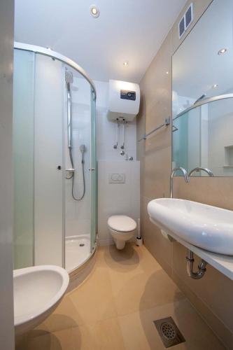 a bathroom with a shower and a sink and a toilet at Villa Makarana Apartments in Makarska