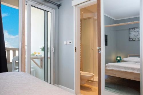 a bedroom with a bed and a bathroom with a toilet at Villa Makarana Apartments in Makarska