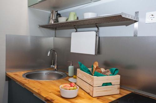 a kitchen counter with a sink and a bowl of fruit at Villa Makarana Apartments in Makarska