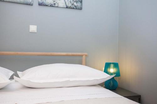a bed with a white pillow and a blue lamp at Villa Makarana Apartments in Makarska