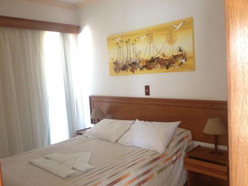 1 dormitorio con 1 cama y 2 toallas blancas en Raio do Sol Residence, en Bombinhas