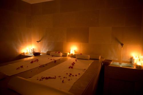 a bedroom with a bed with candles and flowers on it at Relais Histò San Pietro Sul Mar Piccolo in Taranto