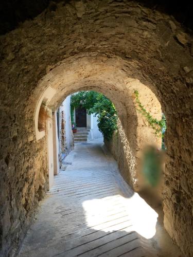 an alley in a stone building with a tunnel at Logis Hôtel Beauséjour in Berre-les Alpes