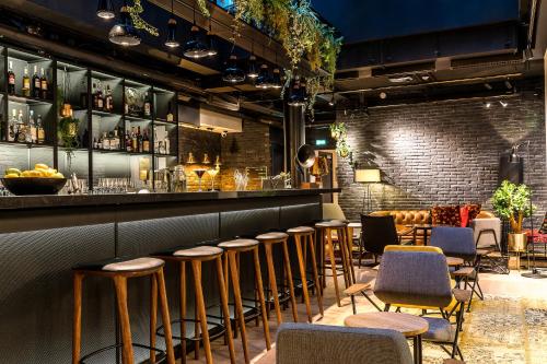 a bar with stools and a row of tables and chairs at Laz' Hotel Spa Urbain Paris in Paris
