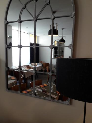 a mirror on the wall of a living room at Hôtel-Restaurant "Chez Carrière" in Aigues-Mortes