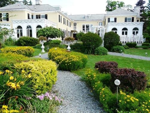 a large white house with a garden of flowers at Lilac Inn in Brandon