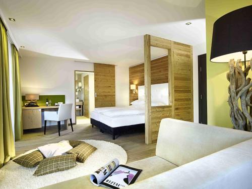 ein Hotelzimmer mit einem Bett und einem Sofa in der Unterkunft Hotel Ritzlerhof - Adults only in Sautens