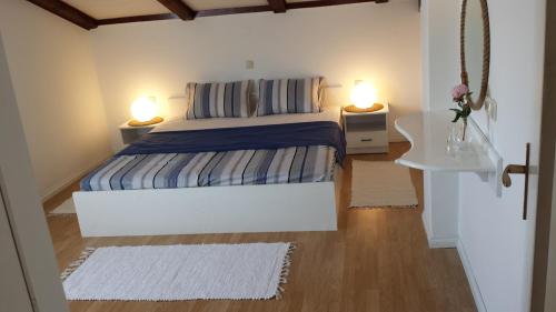 a bedroom with a bed and two lamps on two tables at Sloth in Rab